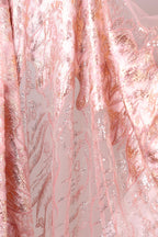 a close-up view of a fabric with a pink and gold pattern, showcasing intricate designs and textures.