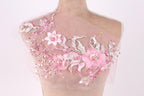 A mannequin wearing a pink floral dress with delicate pink and white flowers and leaves.