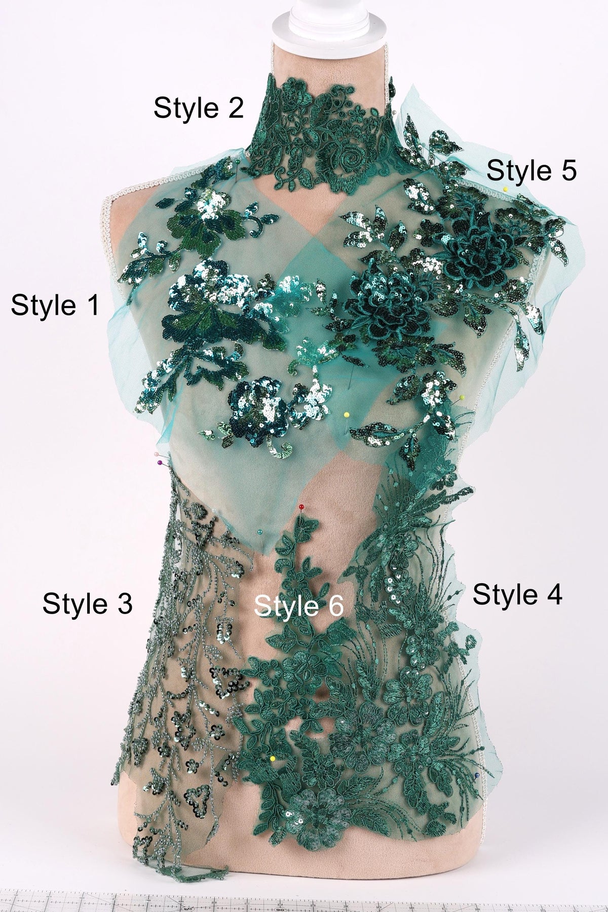 A mannequin wearing a dress with intricate green embroidery and sequins, showcasing various styles.