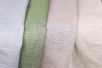 a close-up view of four fabric swatches, each with a different color and pattern of horizontal stripes.