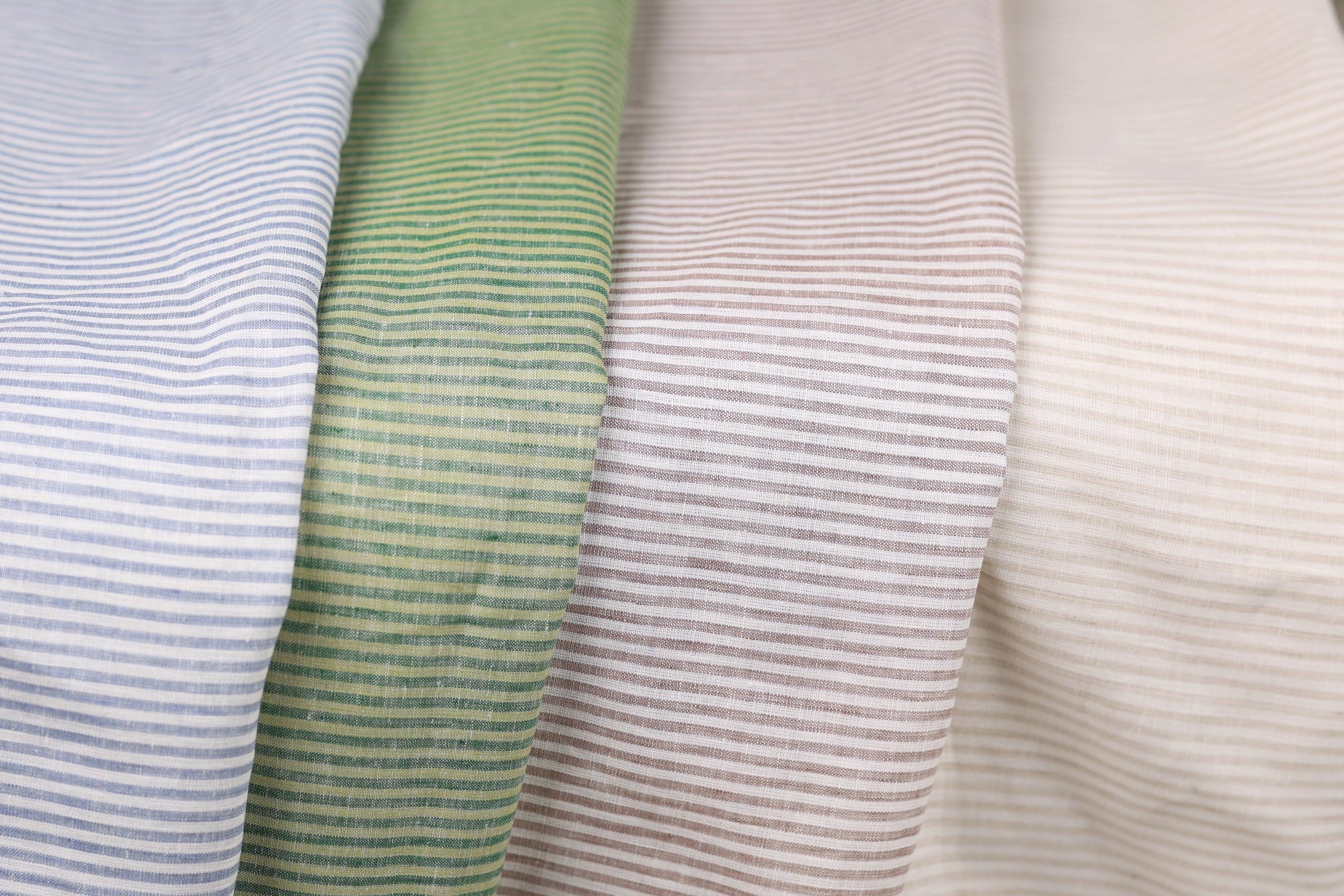 a close-up view of four fabric swatches, each with a different color and pattern of horizontal stripes.