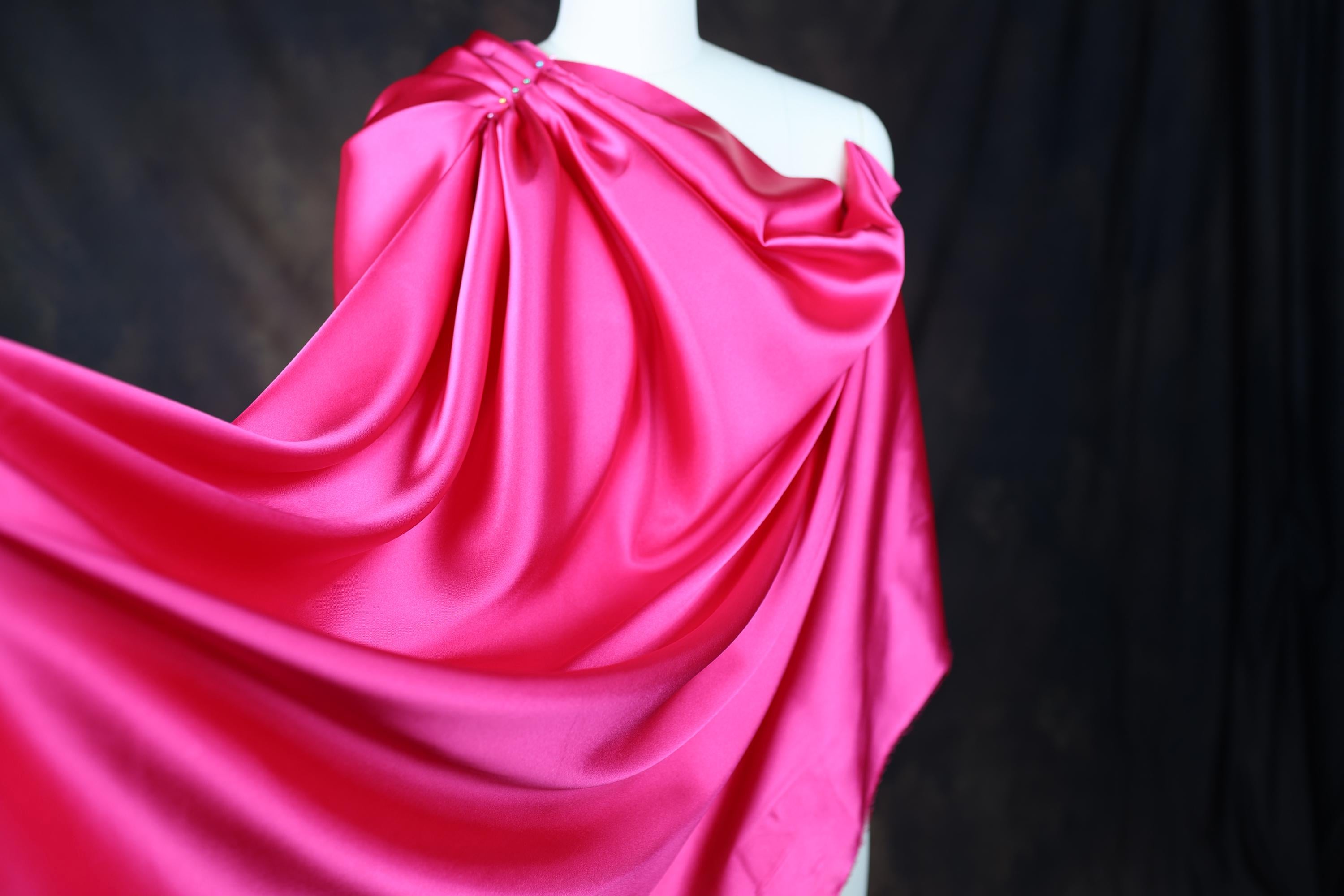 a mannequin wearing a pink draped dress