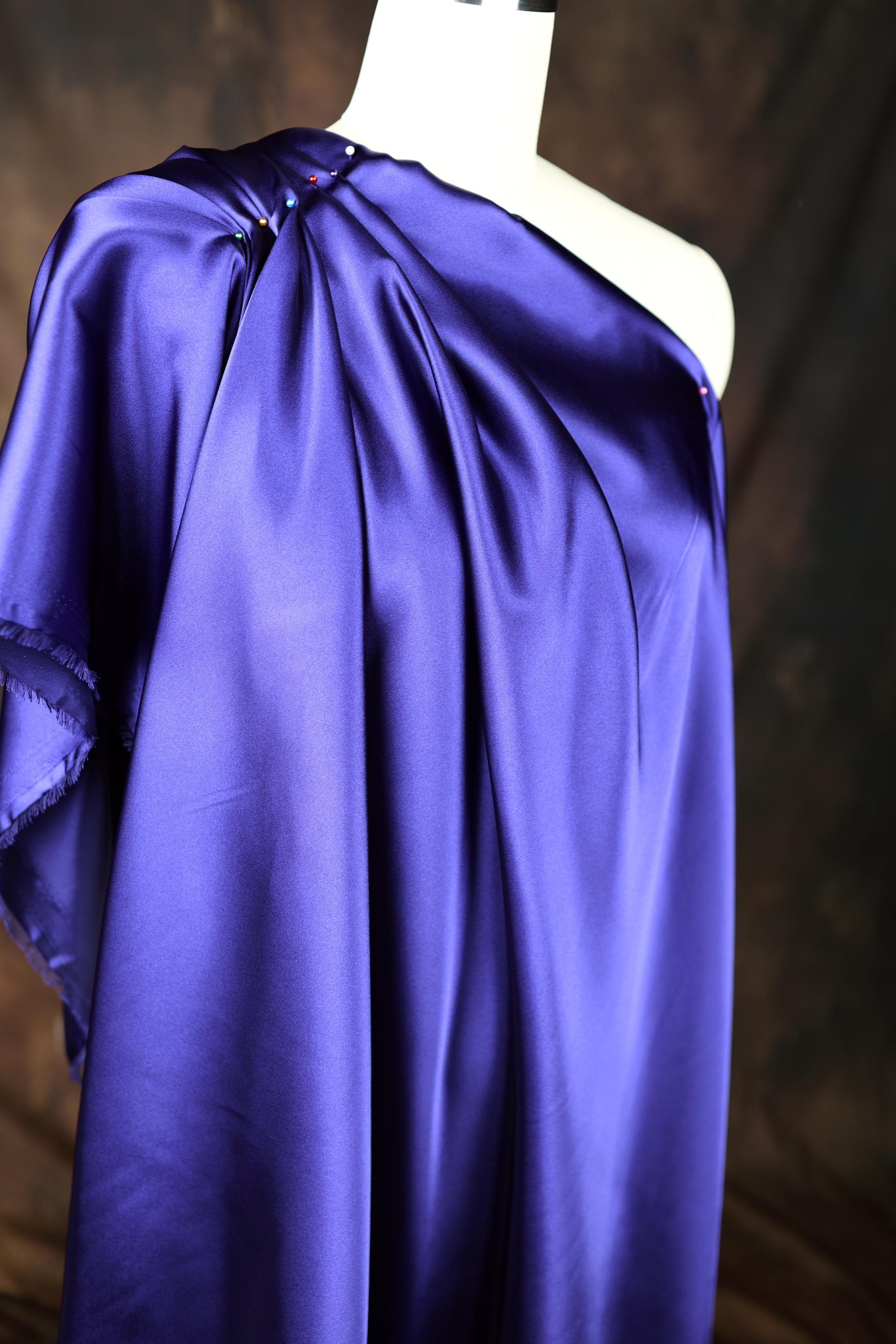 a dress on a mannequin with a purple cape on top of it