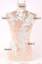 A mannequin with various styles of lace and floral embroidery displayed on its bust and shoulders.