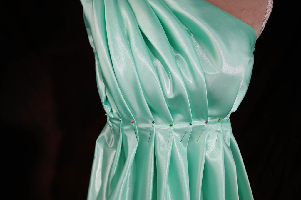 a woman's green dress is shown on a mannequin