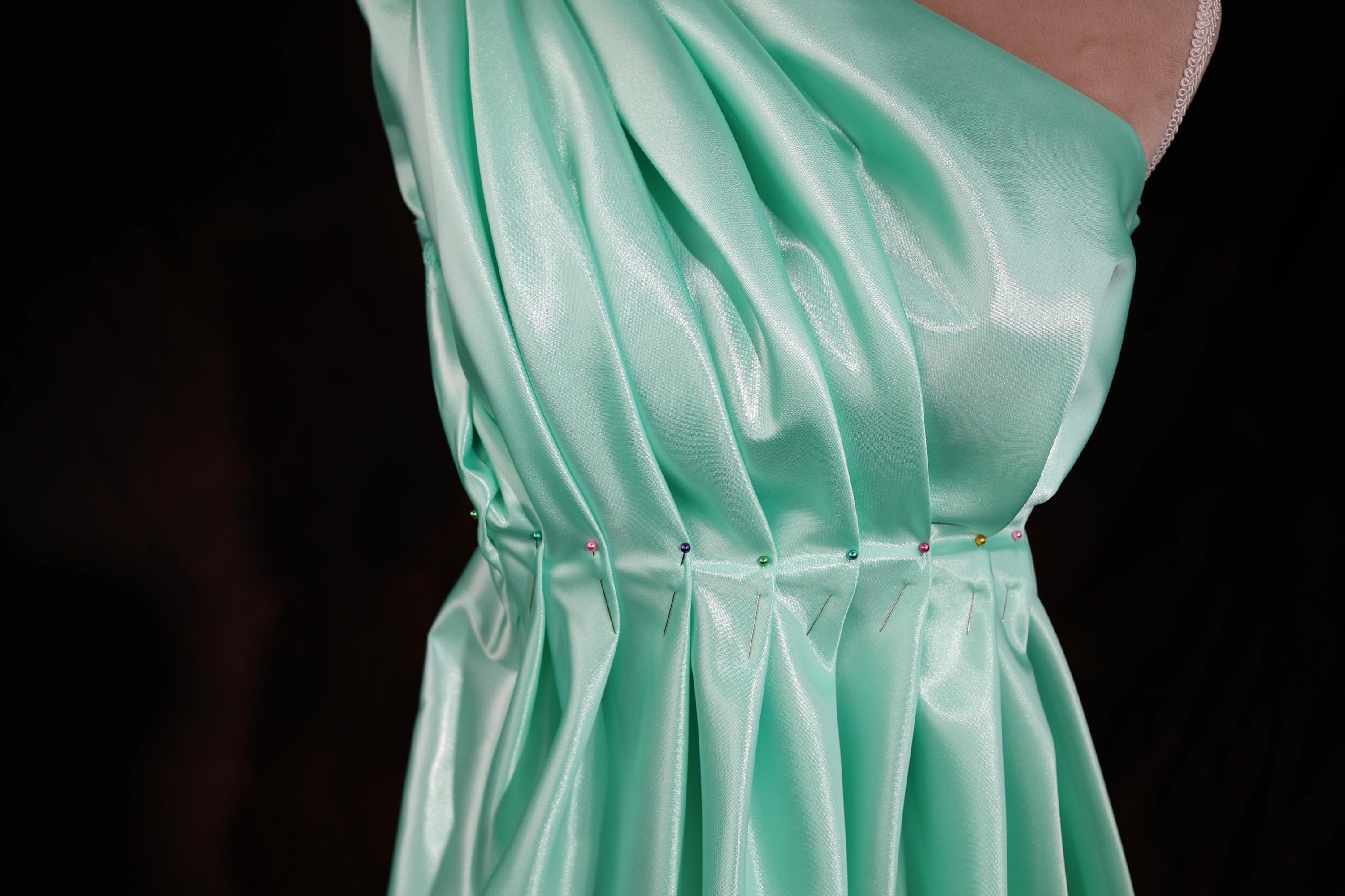 a woman's green dress is shown on a mannequin