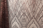 a close-up view of a fabric with a repeating pattern of sequin designs in shades of brown and black. The pattern appears to be a geometric design with a repeating diamond shape and lines, creating a visually striking and intricate design.