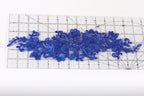 a clear ruler with blue floral embroidery designs placed on it.