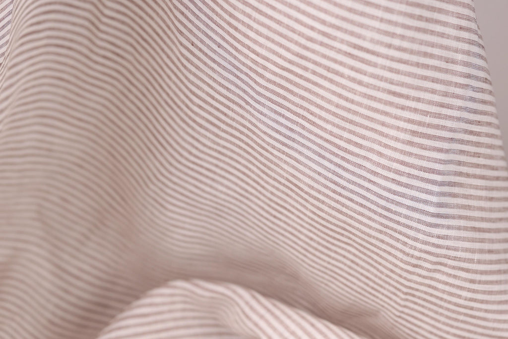 A close-up view of a fabric with horizontal brown and white stripes, creating a textured and visually interesting pattern.
