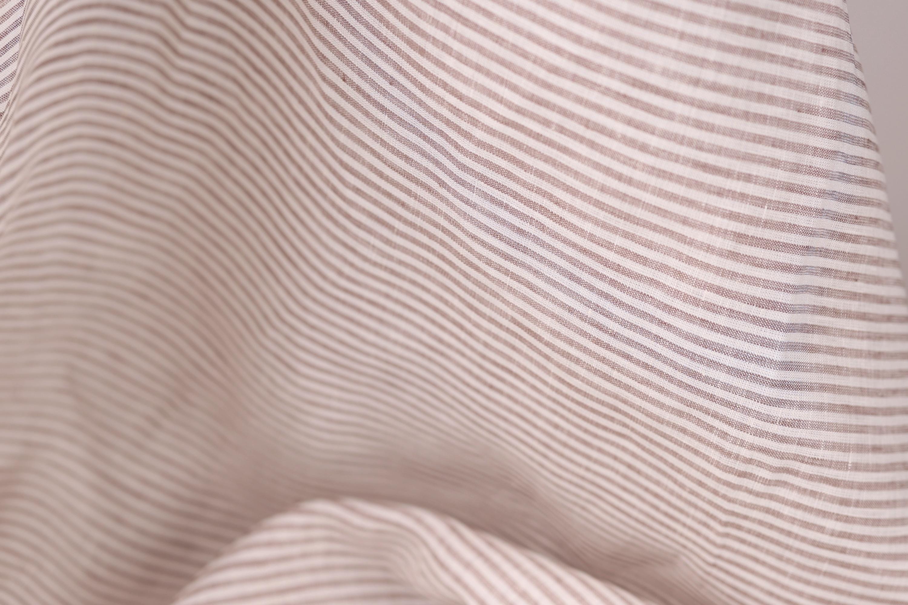 A close-up view of a fabric with horizontal brown and white stripes, creating a textured and visually interesting pattern.