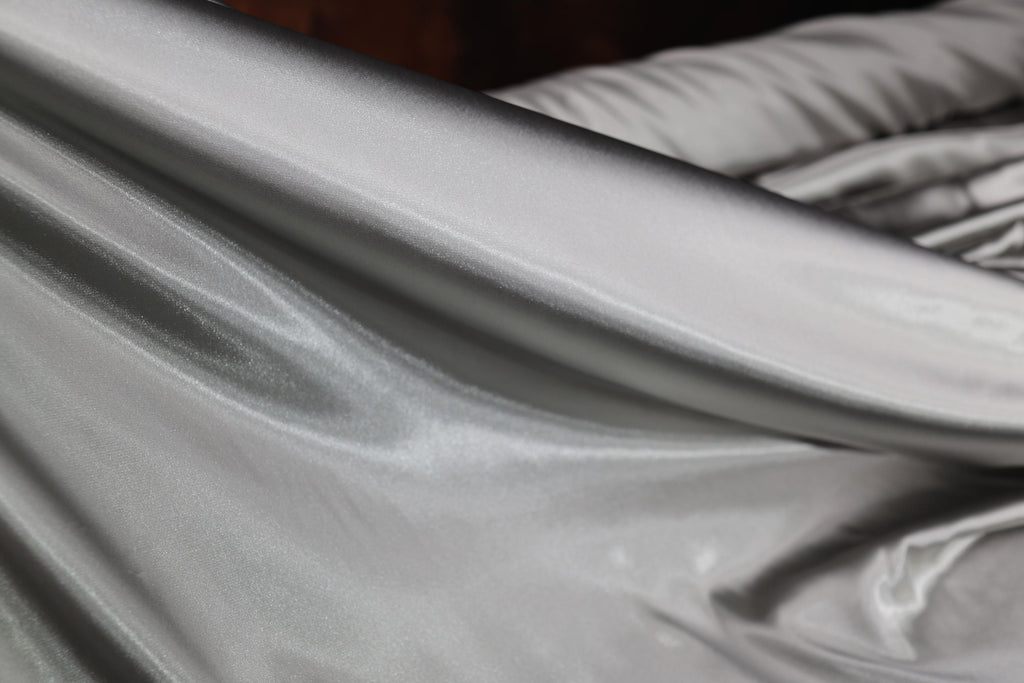 a close up of a silver sheet on a bed