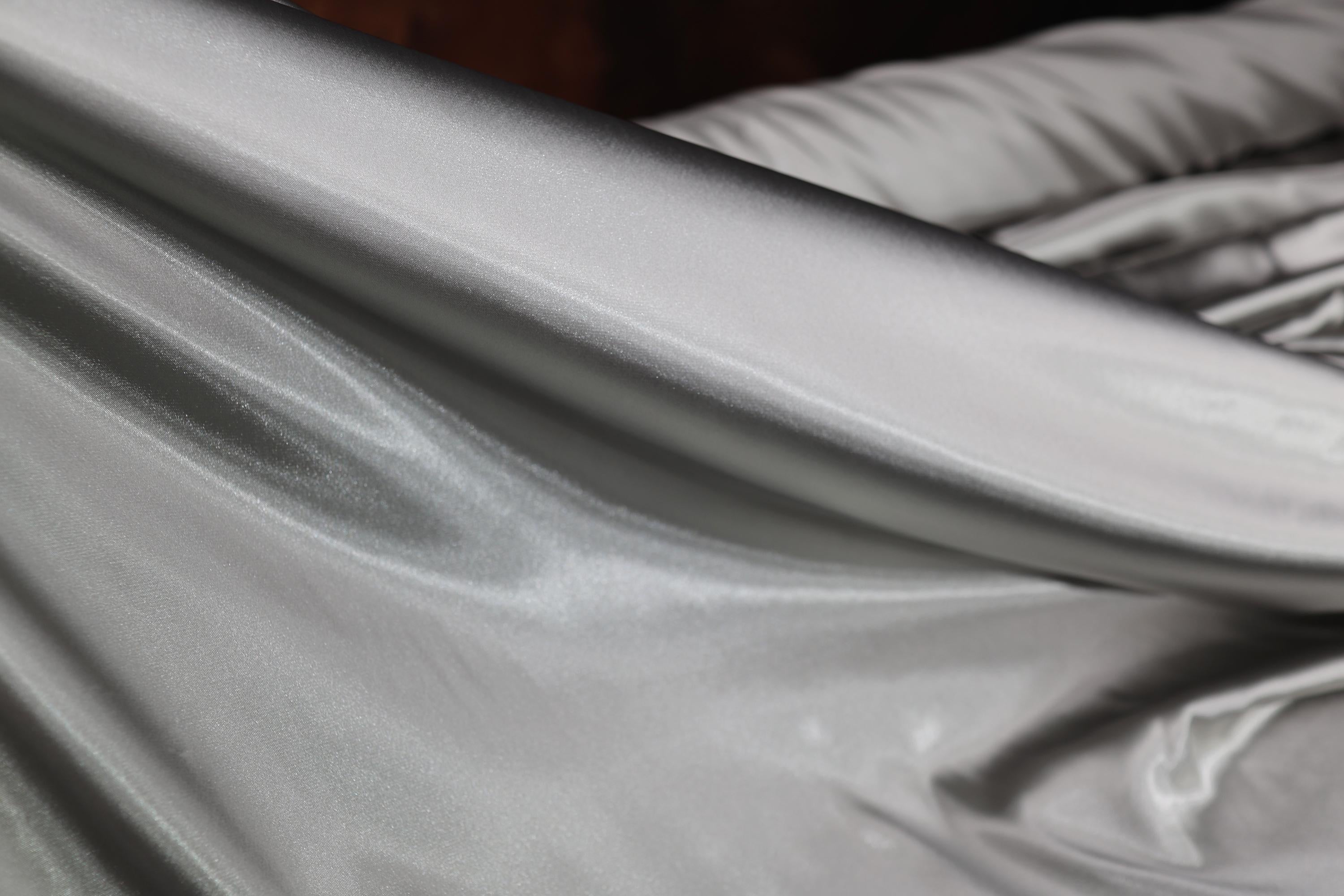 a close up of a silver sheet on a bed