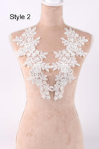 A mannequin wearing a white lace bodice with floral patterns.