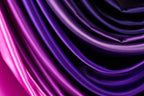 a close-up view of a fabric with a gradient of purple and pink colors, creating a visually striking and vibrant pattern.
