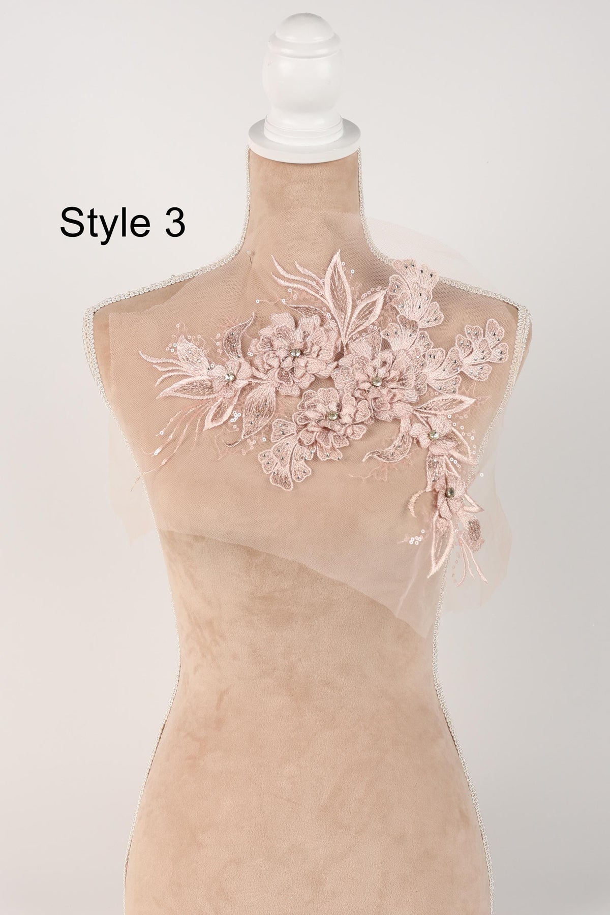 A mannequin with a decorative floral lace piece on its bust, displayed against a plain background.