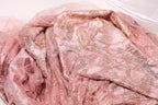 a close-up view of a pink and gold sequined fabric, possibly a dress or garment.