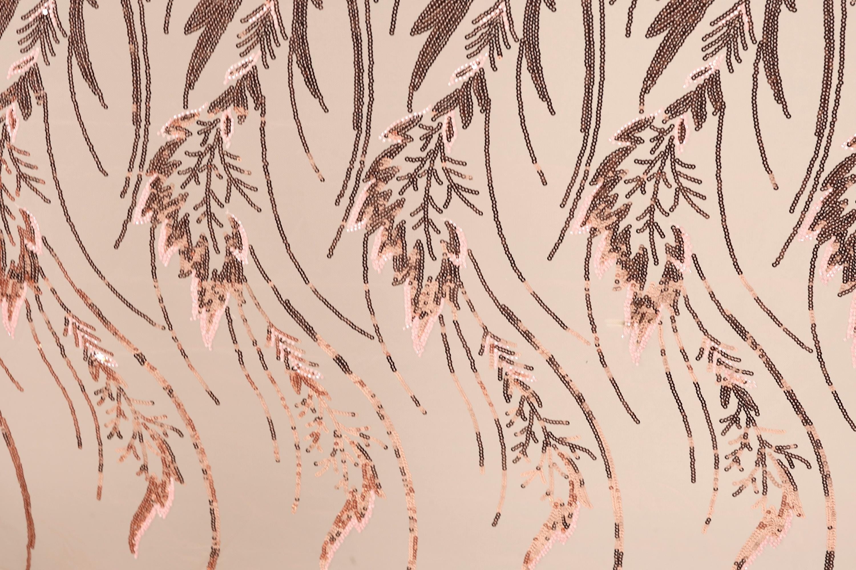 a close-up view of a patterned fabric with a repeating design of brown leaves and stems. The leaves appear to be made of sequins or beads, creating a textured and visually interesting surface.