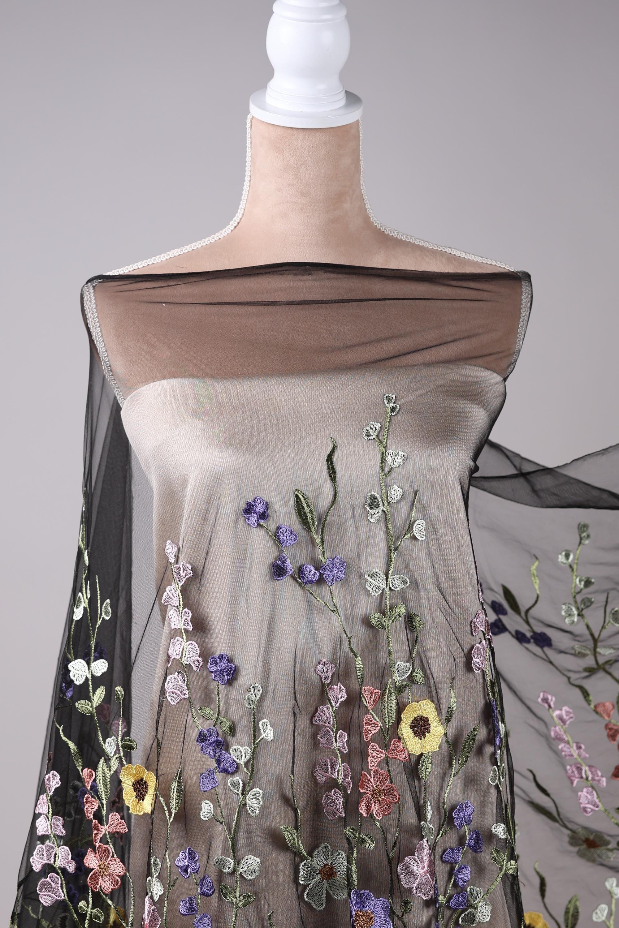 A mannequin wearing a dress with a floral pattern on the bodice and sleeves.
