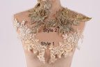 A mannequin with a decorative collar featuring intricate gold and white floral patterns.