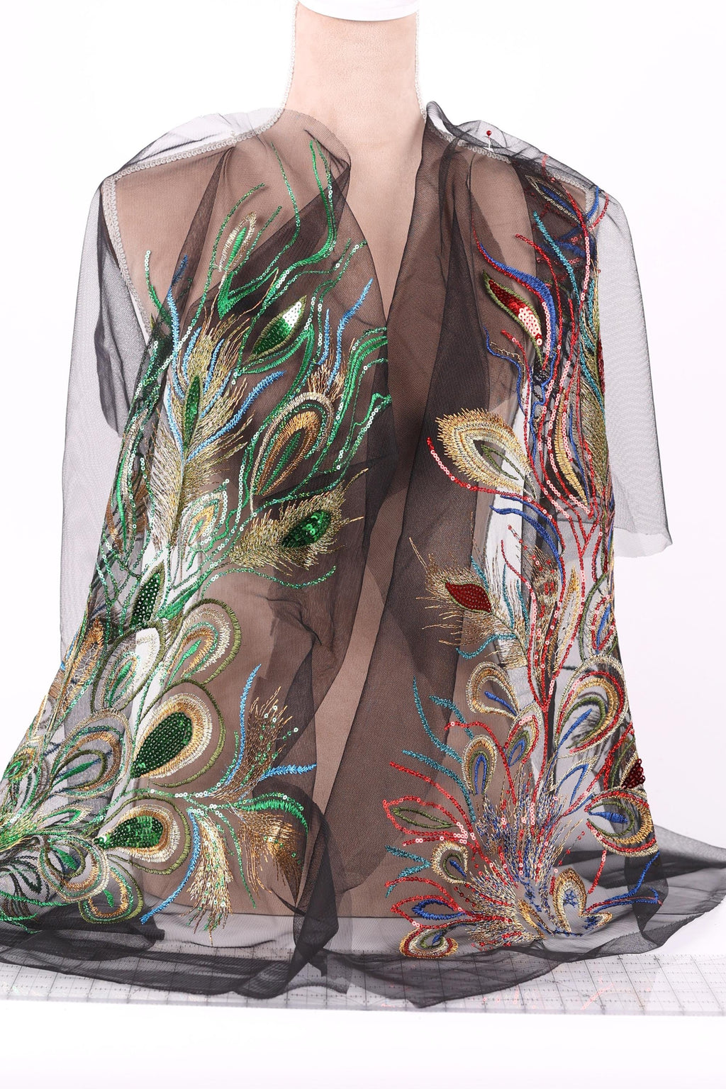 a mannequin wearing a black sheer dress with intricate, colorful embroidered designs.
