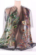 a mannequin wearing a black sheer dress with intricate, colorful embroidered designs.