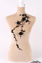 A mannequin with a beige body and black floral embroidery on its bust area.