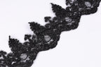 a close-up view of a black lace trim or ribbon, with intricate patterns and textures.