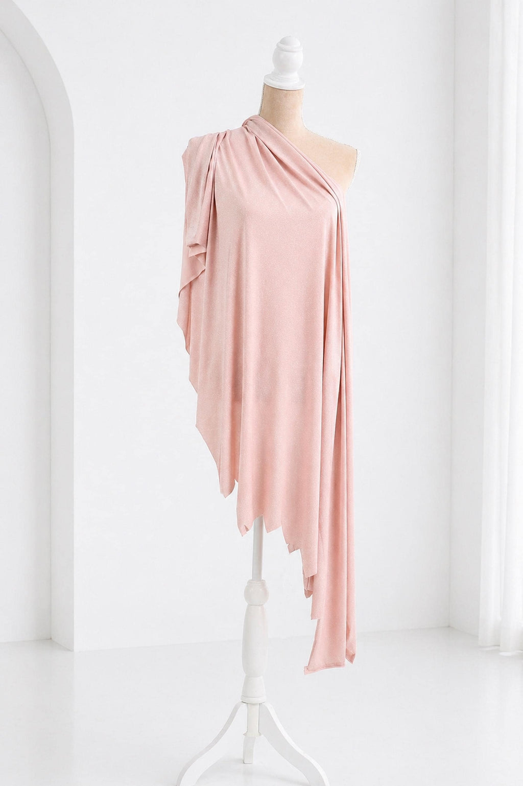 A mannequin wearing a pink one-shoulder dress with a draped, flowing fabric draped over the shoulder.