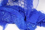 a close-up view of a piece of blue sequin fabric, with its intricate patterns and sparkling texture clearly visible.