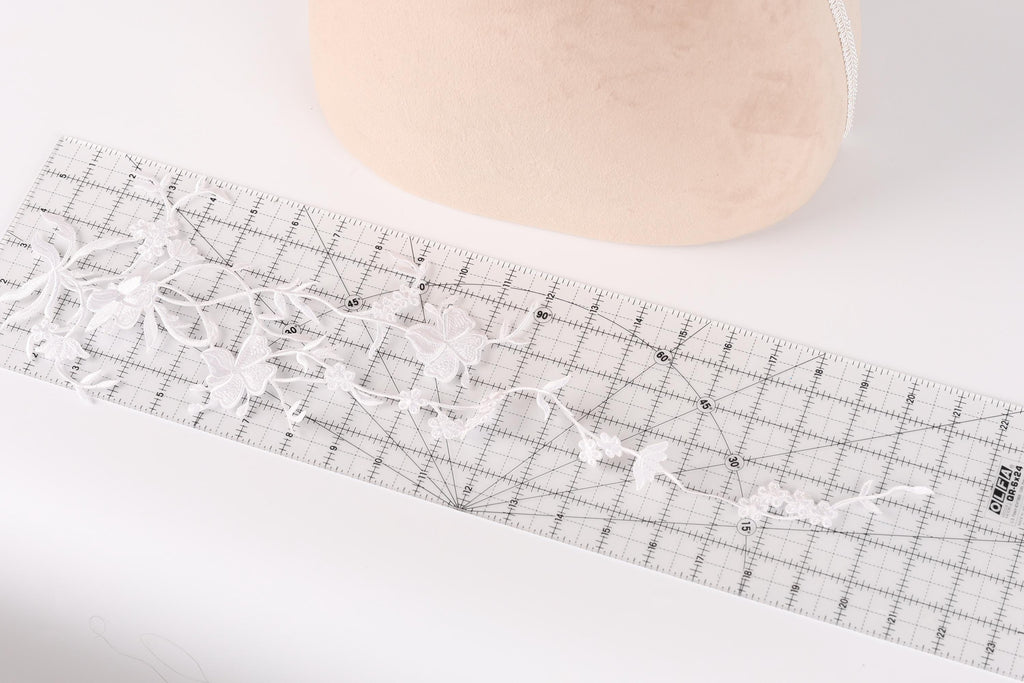 a ruler with a floral pattern on it, placed on a white surface.