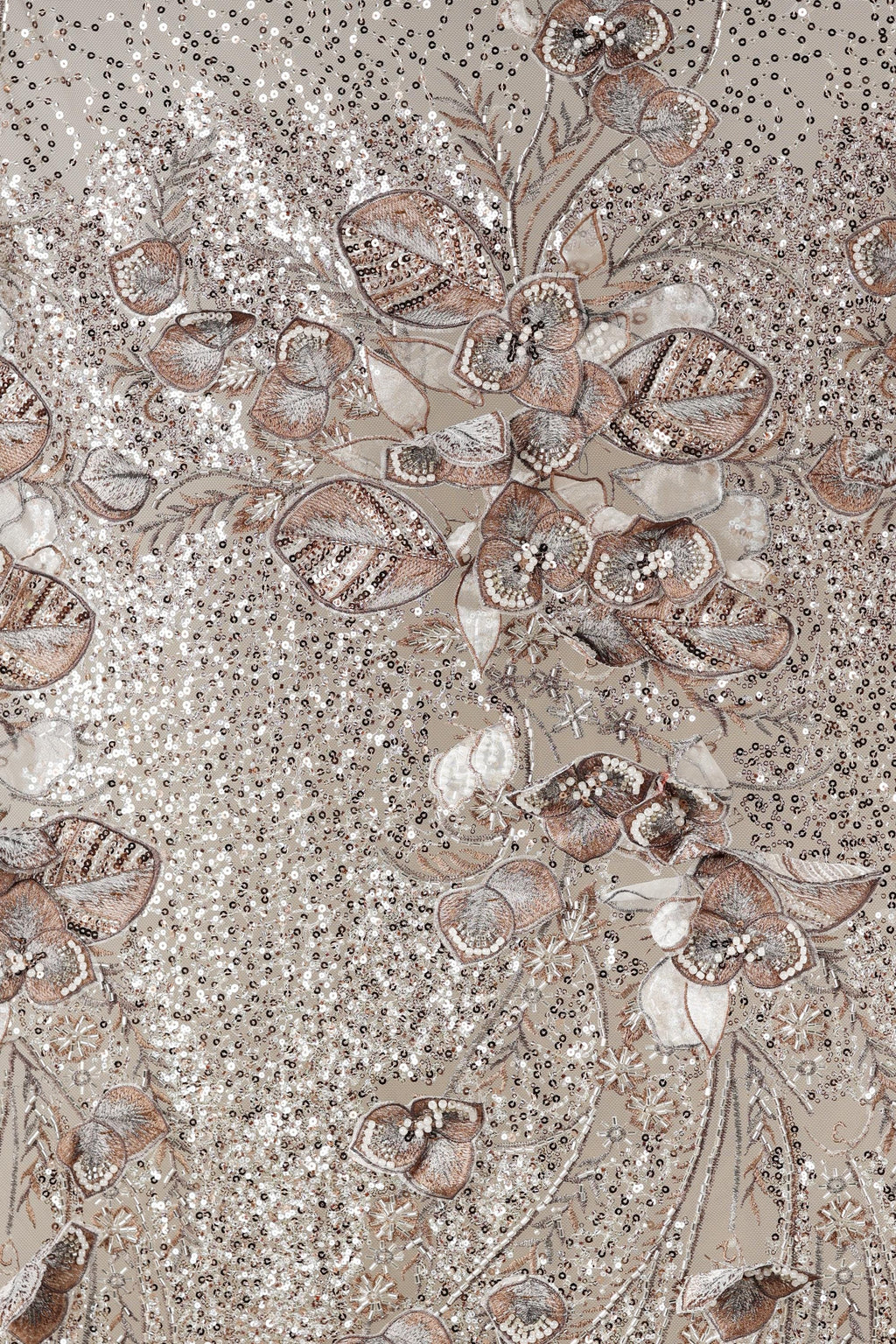 The image is a close-up of a fabric with a floral pattern, featuring a variety of flowers and leaves in shades of brown and beige. The pattern is intricate and detailed, with the flowers and leaves appearing to be made of sequins or other embellishments. The overall composition of the image is visually appealing and showcases the craftsmanship of the fabric design.
