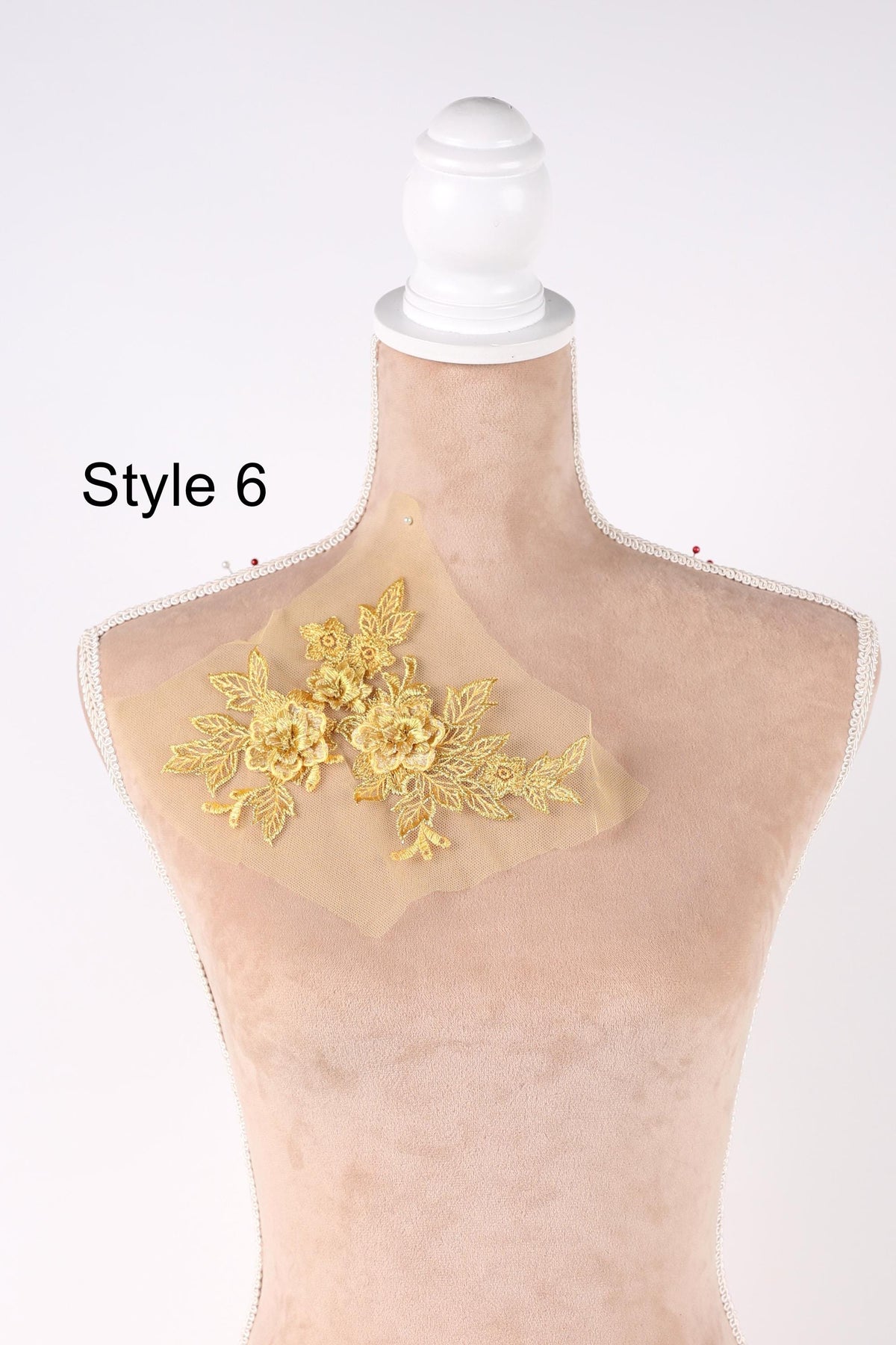 A mannequin with a decorative gold floral embroidery on its bust.