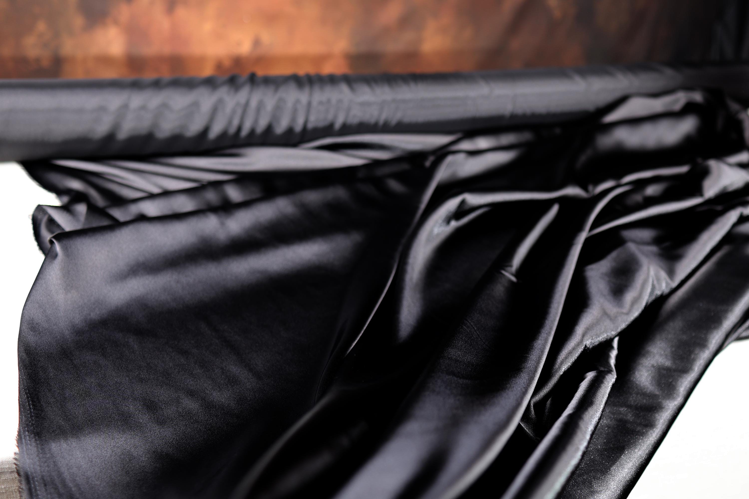 a close up of a bed with black sheets