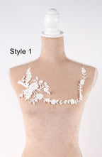 A mannequin with a white lace design on its bust, featuring a floral pattern.