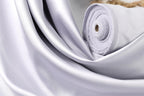 A close-up view of a white satin fabric, possibly silk, with a smooth and shiny texture.