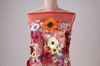 A mannequin wearing a red dress with a floral pattern.