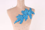 A mannequin with a decorative blue floral piece on its shoulder.