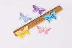 a wooden ruler with colorful butterfly patches on it, including blue, purple, yellow, pink, and white butterflies.