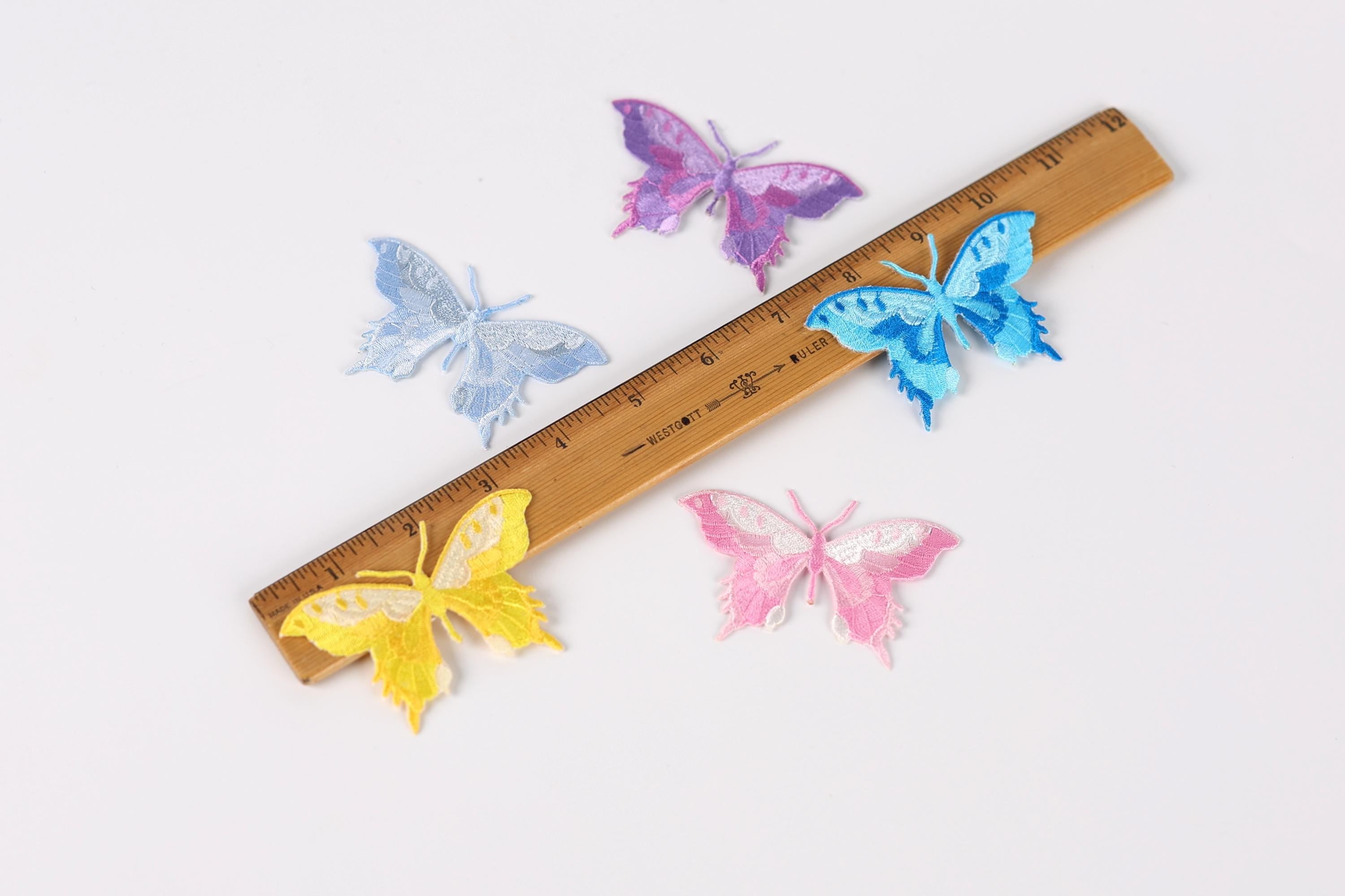 a wooden ruler with colorful butterfly patches on it, including blue, purple, yellow, pink, and white butterflies.