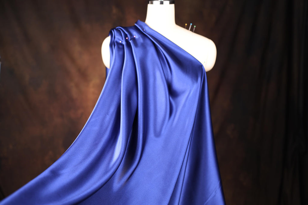a mannequin wearing a blue draped dress