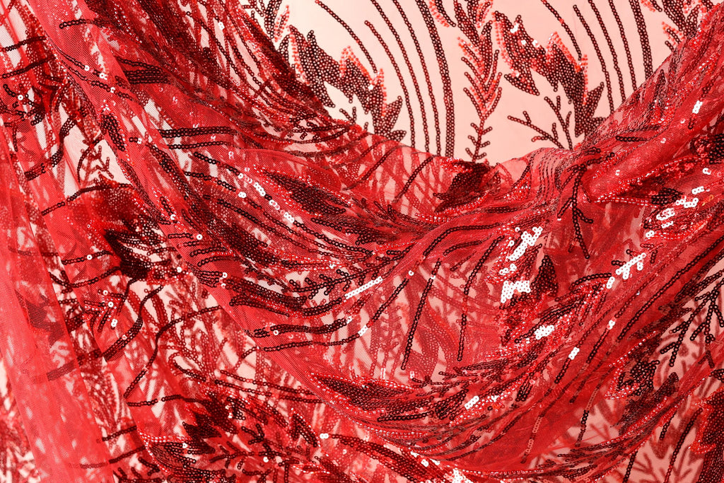 The image is a close-up view of a fabric with a red and black sequin pattern, featuring a floral design.