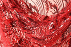 The image is a close-up view of a fabric with a red and black sequin pattern, featuring a floral design.