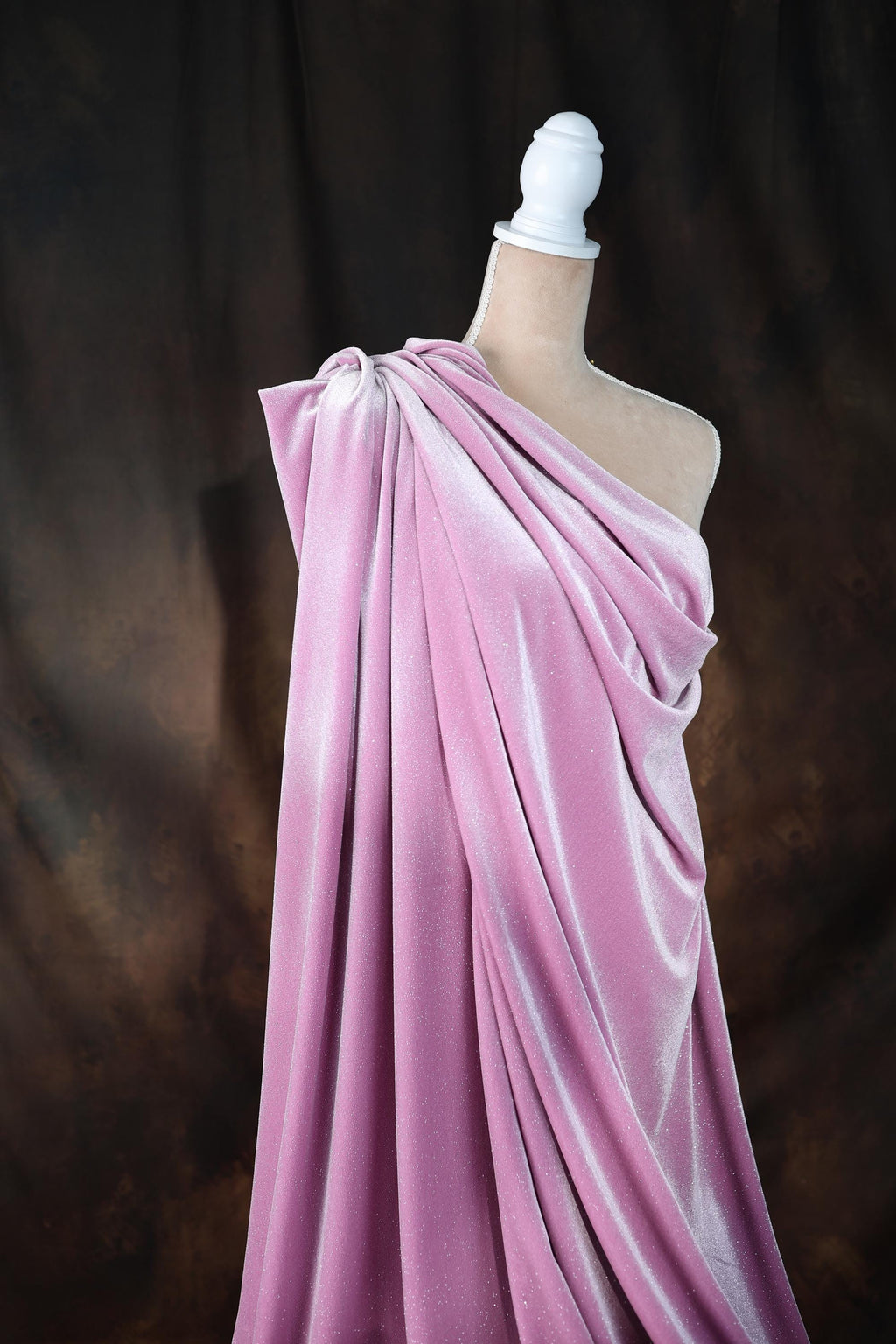 a mannequin wearing a pink draped dress