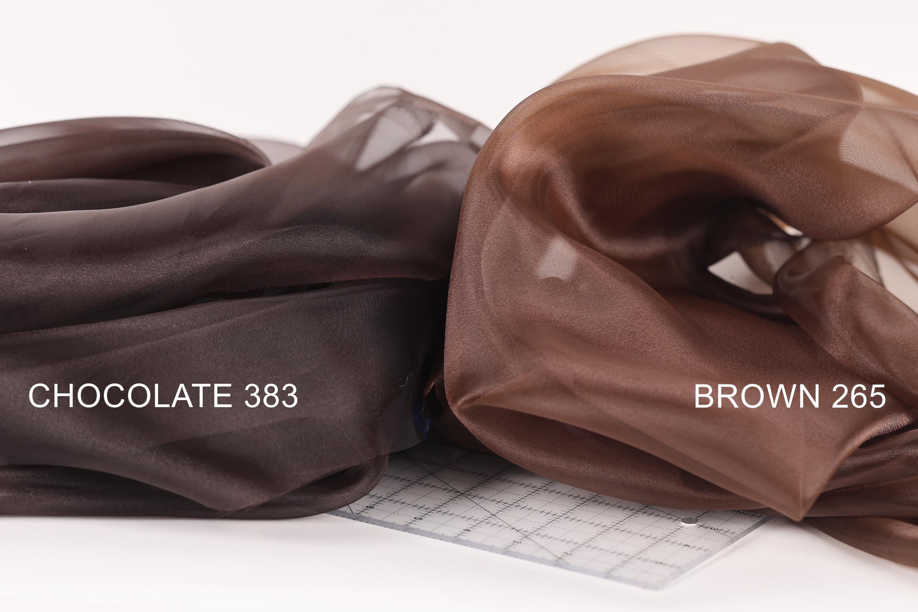 two pieces of brown fabric, one labeled "Chocolate 383" and the other labeled "Brown 265", placed side by side on a white surface.