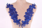 A mannequin torso with a decorative blue lace overlay featuring intricate floral patterns.