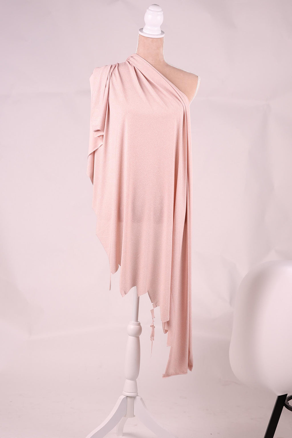 A mannequin wearing a pink one-shoulder dress with a draped, flowing fabric draped over the shoulder.