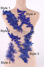 A mannequin with various blue floral and leaf-like designs attached to its torso, each with a different style number.