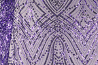 a close-up view of a fabric with a purple and black pattern, including a repeating diamond-shaped motif and a zigzag pattern. The fabric appears to be made of sequins or beads, creating a visually striking and intricate design.