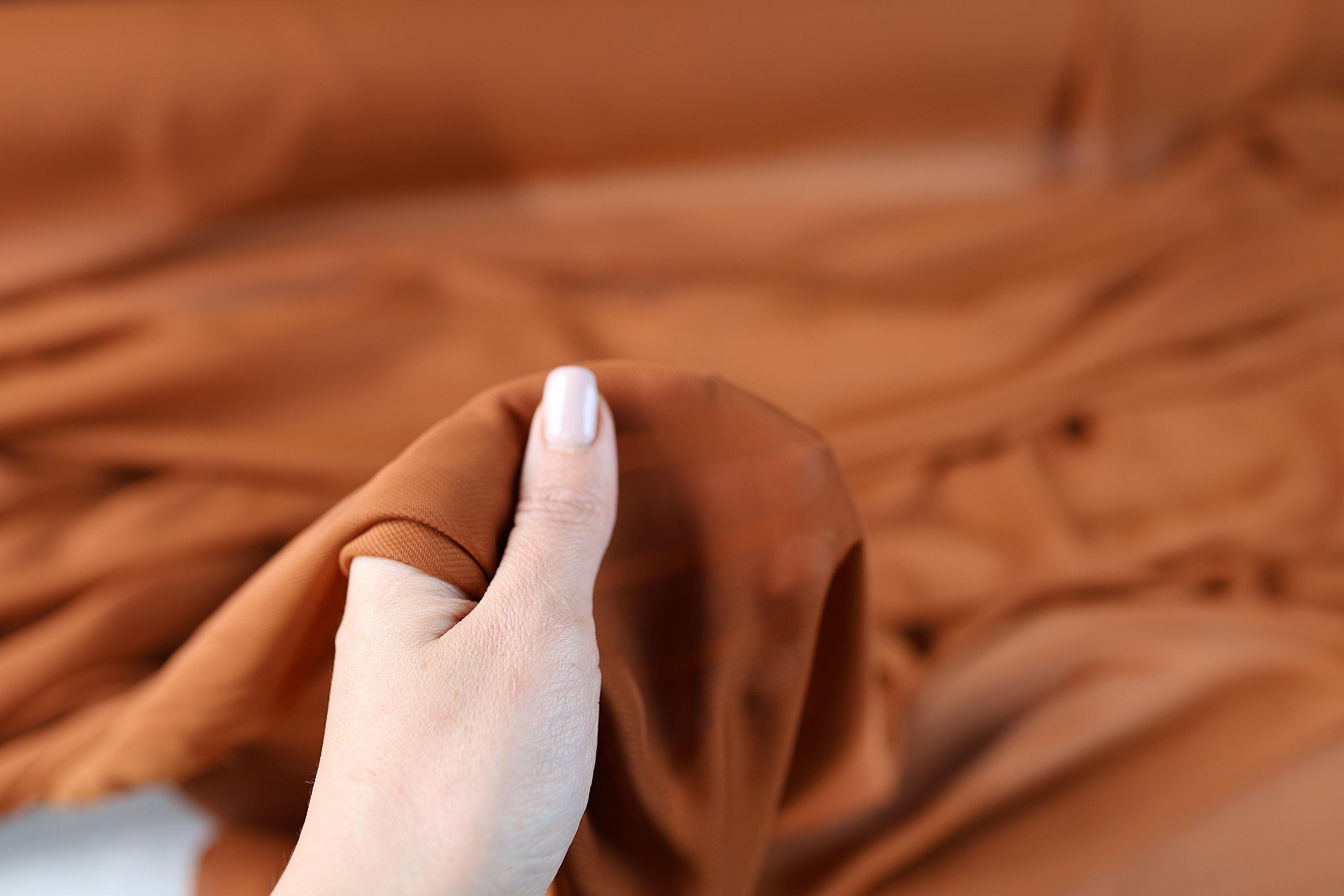 a woman&#39;s hand holding a brown cloth