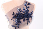 A mannequin torso with a decorative fabric piece featuring a floral pattern in shades of blue and black.